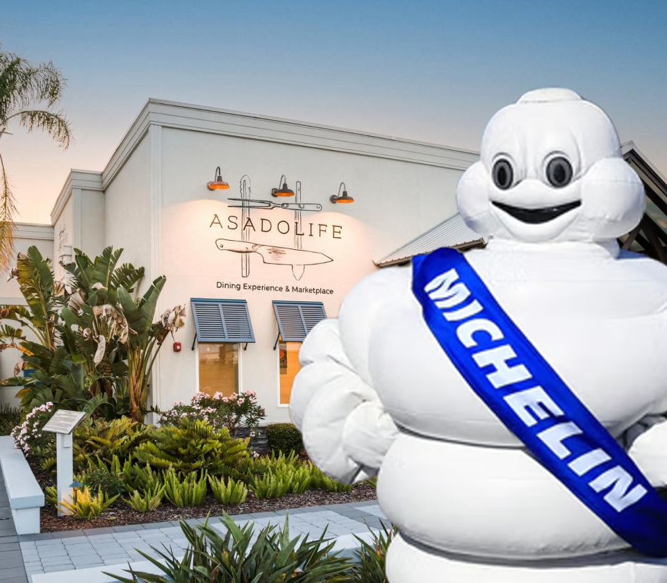 Michelin Man standing outside Asado Life in St. Augustine, one of four local restaurants recognized in the 2026 Michelin Guide.