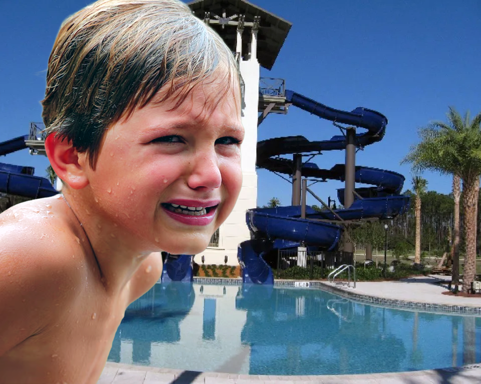 Crying child standing beside a resort-style neighborhood pool with large blue waterslides in Nocatee.