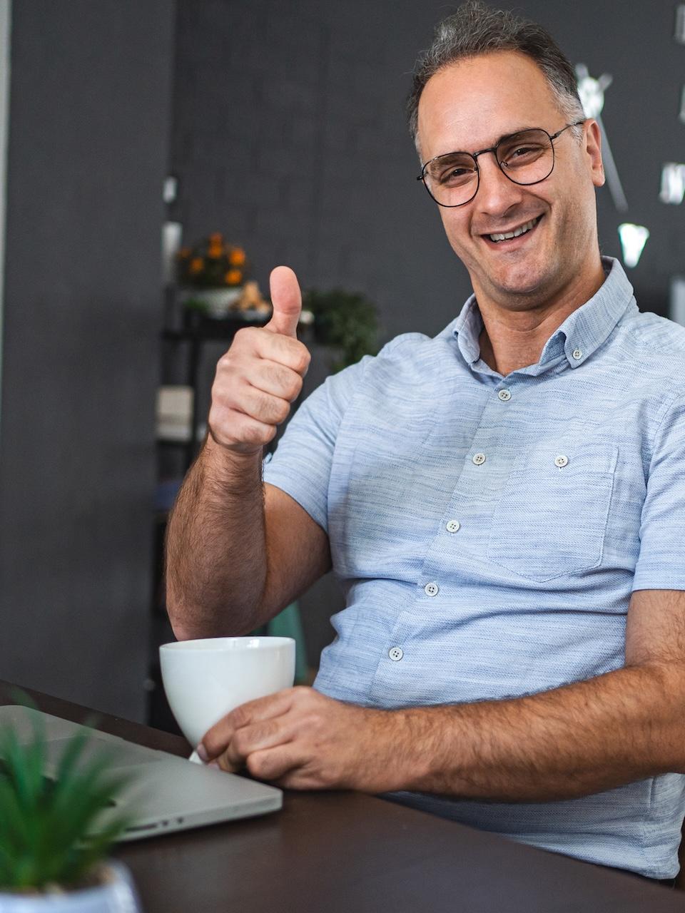 A fictional St. Johns County land-use expert gives a thumbs-up while working from his kitchen table.