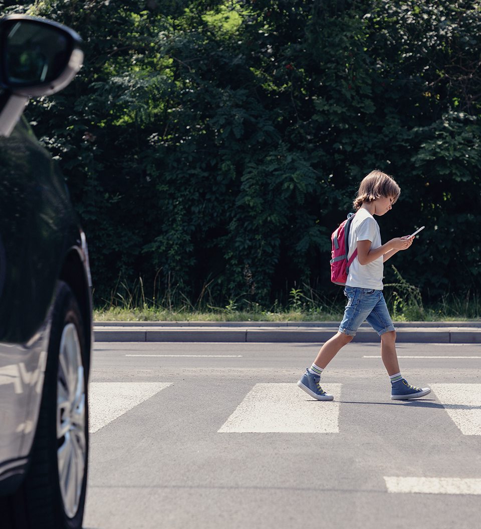 Satirical image of a child standing near Courtney Vista Drive outside Magnolia Oaks Academy, highlighting concerns about unsafe walking conditions.